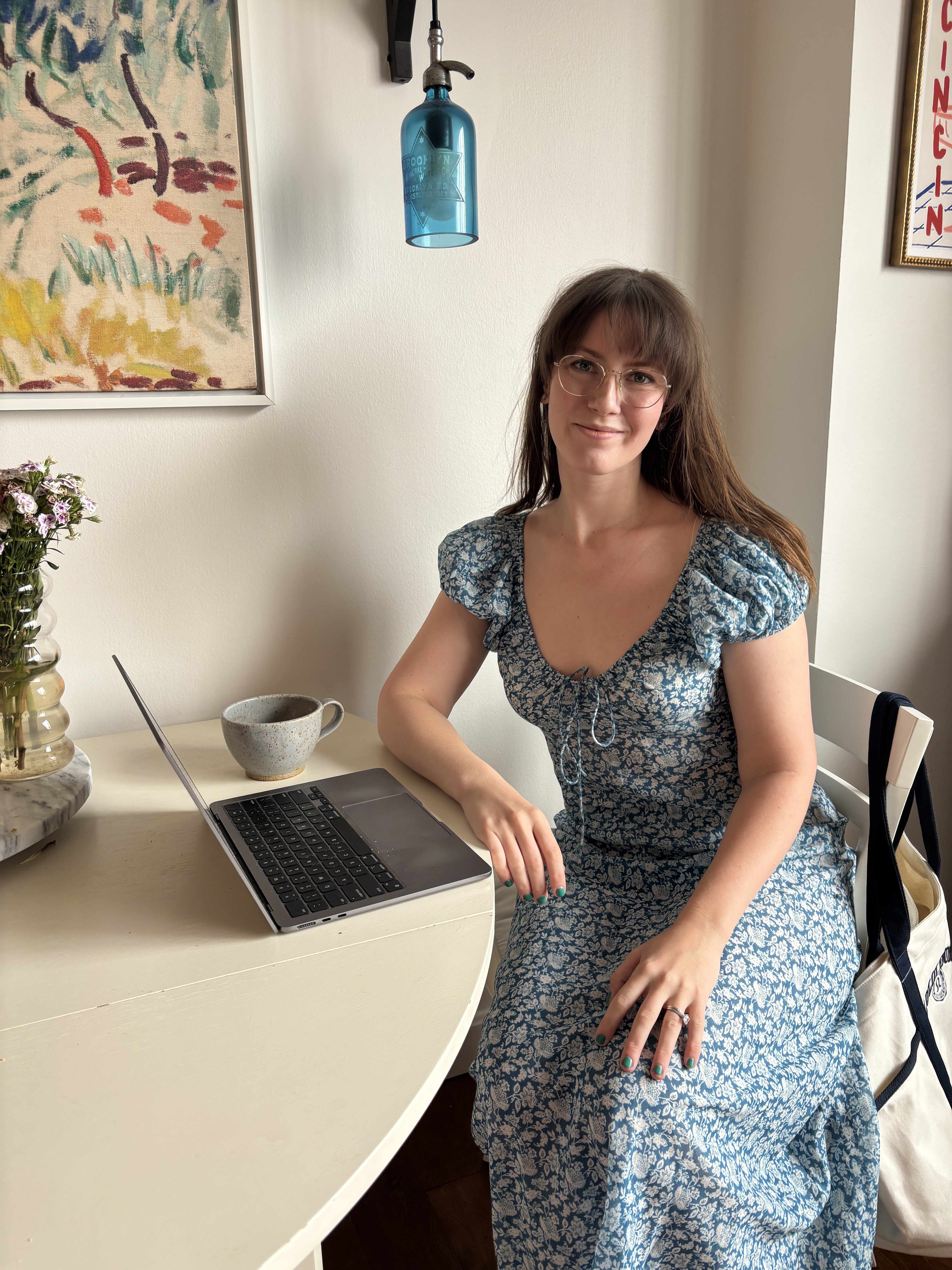 Halie LeSavage wears a Dôen dress owned by Taylor Swift while sitting at a table