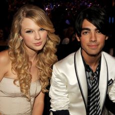 Taylor Swift in a beige strapless dress and Joe Jonas in a white blazer and striped shirt at the 2008 MTV Video Music Awards