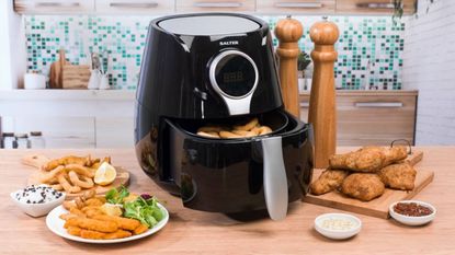 A lifestyle image of a Salter air fryer surrounded by food