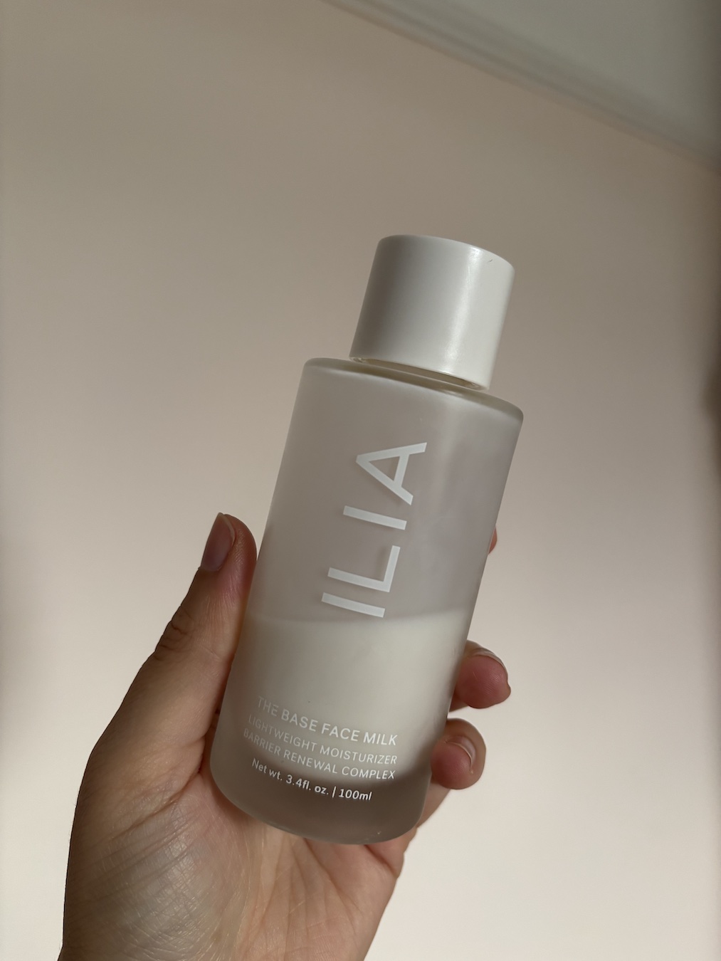 Mica Ricketts holding ILIA The Base Face Milk