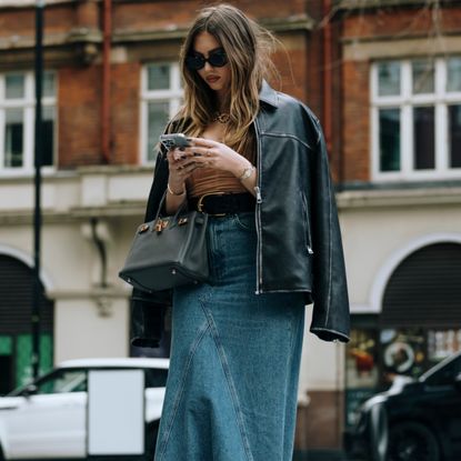 woman wearing a denim skirt and a leather jacket 