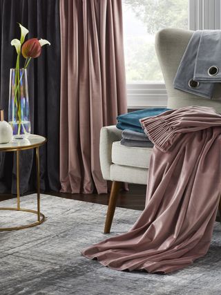 Fabric pink curtains trailing on gray area rug