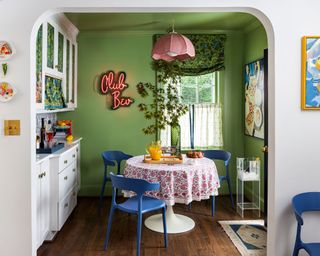 breakfast room color drenched in bright green paint, colorful decor throughout the room