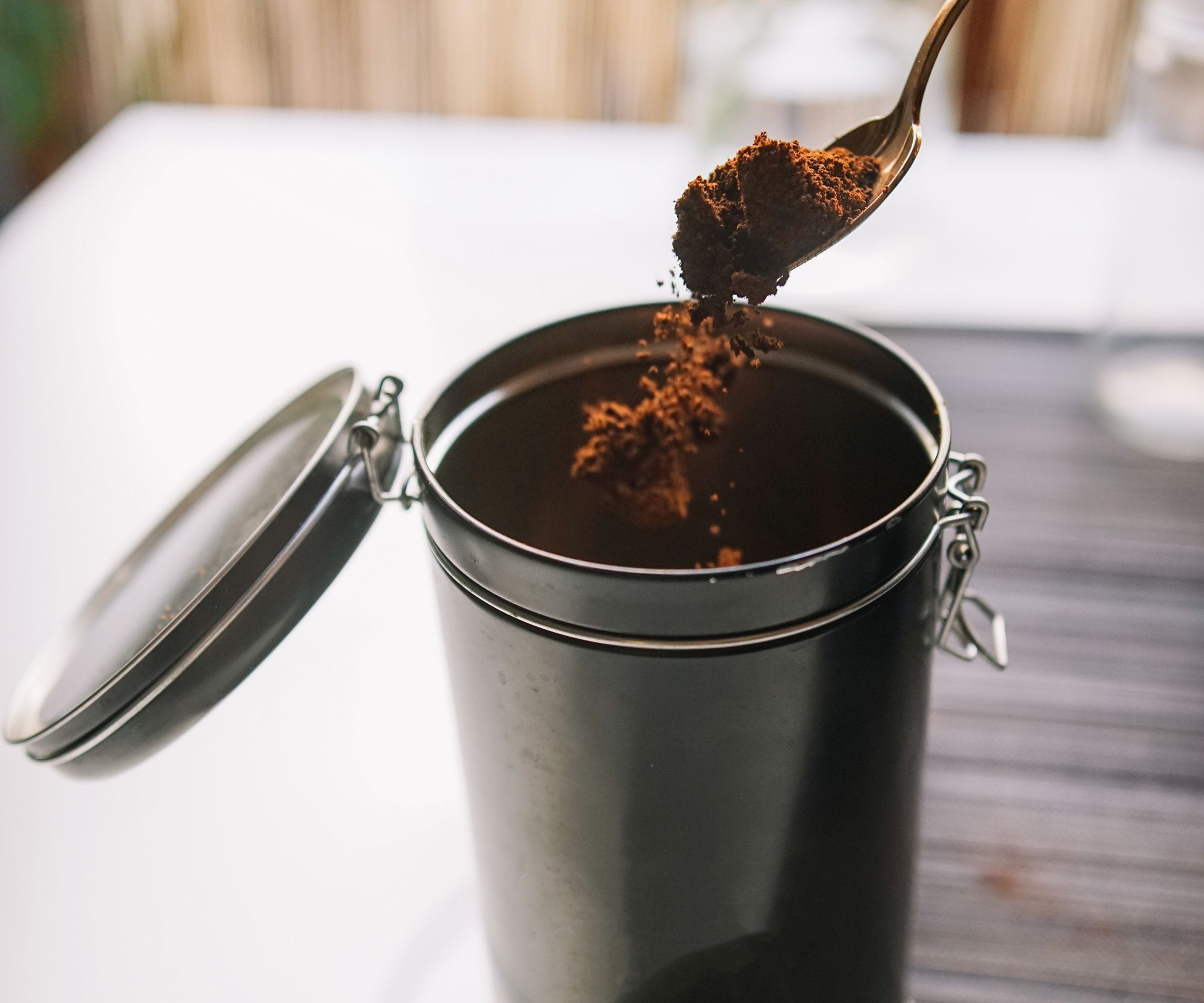 Instant coffee being scooped out a cannister
