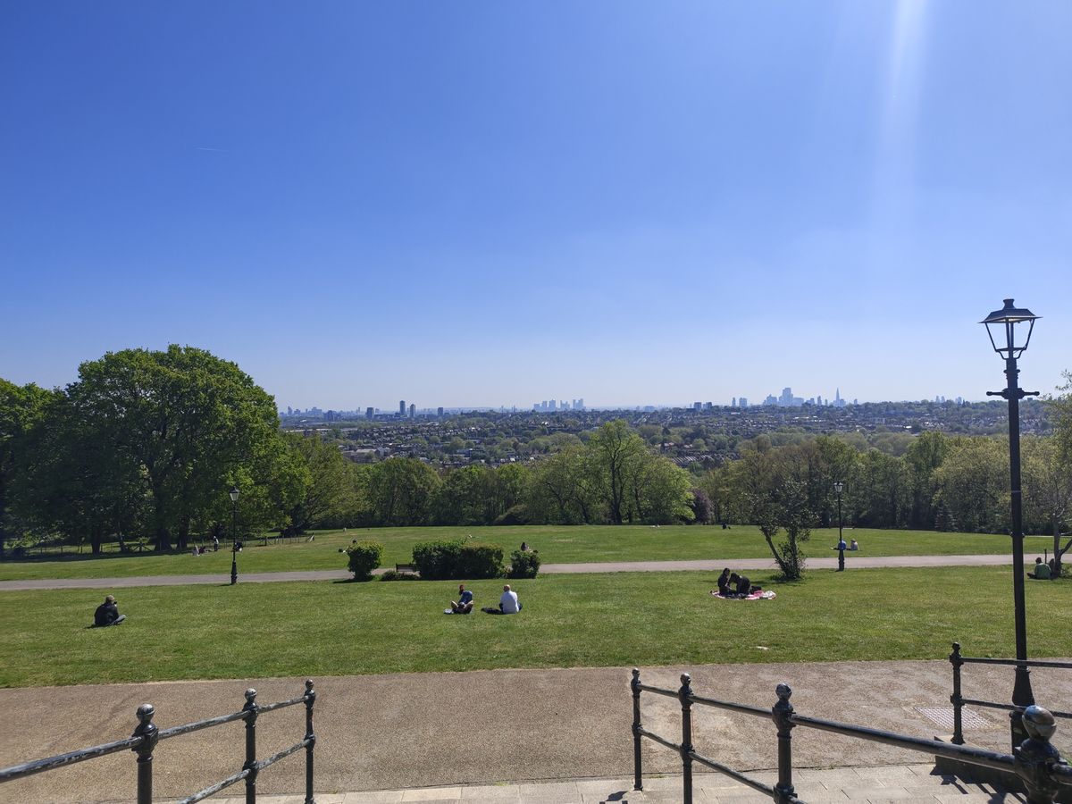 A camera sample taken on the Motorola Edge 70 Fusion, showing a park and distant city-scape.