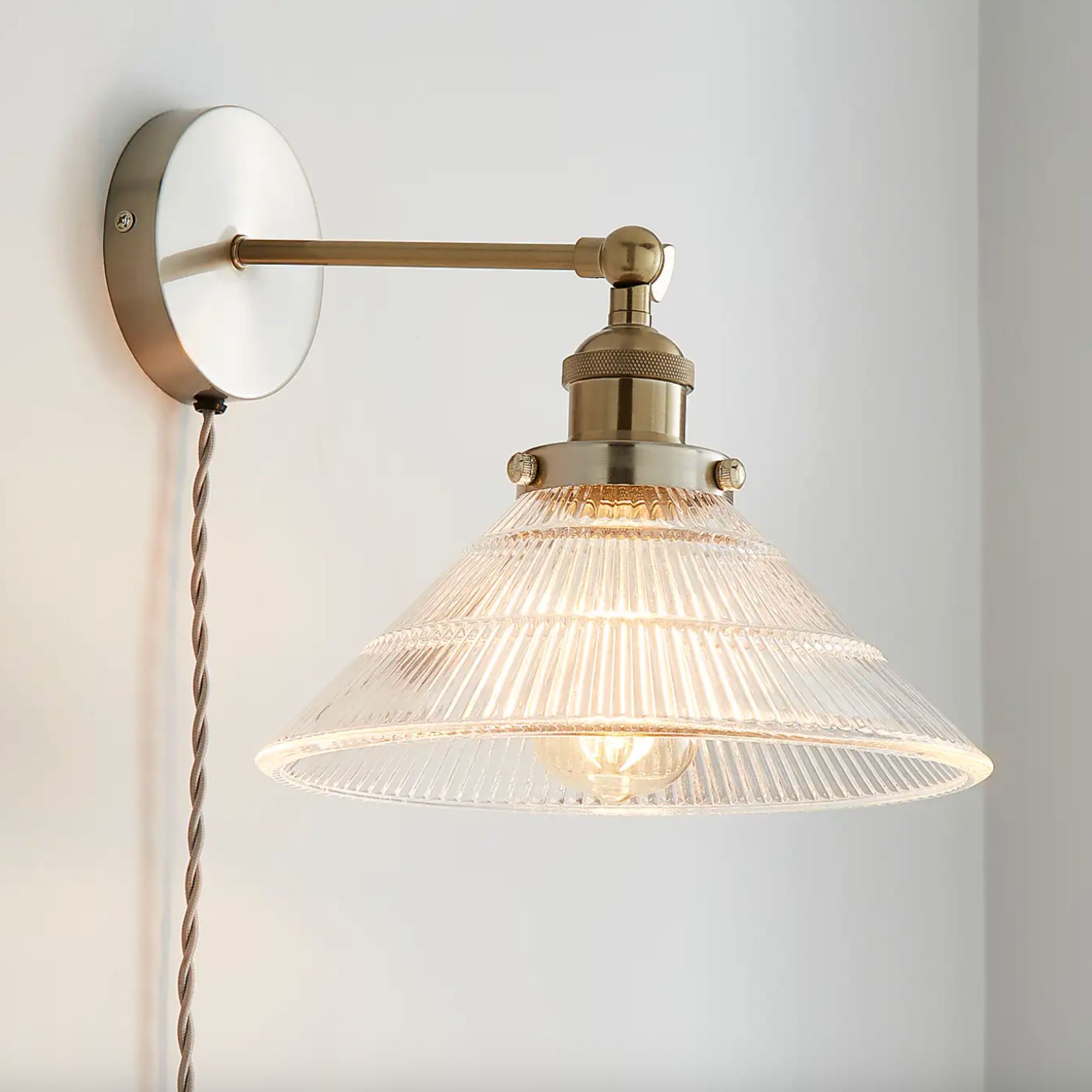 Logan Glass Plug in Wall Light with brass fitting and glass light, switched on