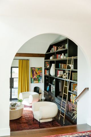 A living room with a wall full of books