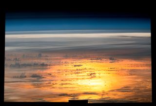 Orange glow below clouds on the surface of earth