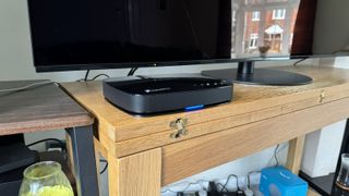 Humax Aura smart PVR viewed straight-on in front of a TV