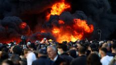 Plumes of black smoke rise during a violent anti-government protest by students in Tirana, Albania