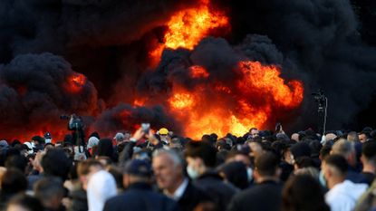 Plumes of black smoke rise during a violent anti-government protest by students in Tirana, Albania