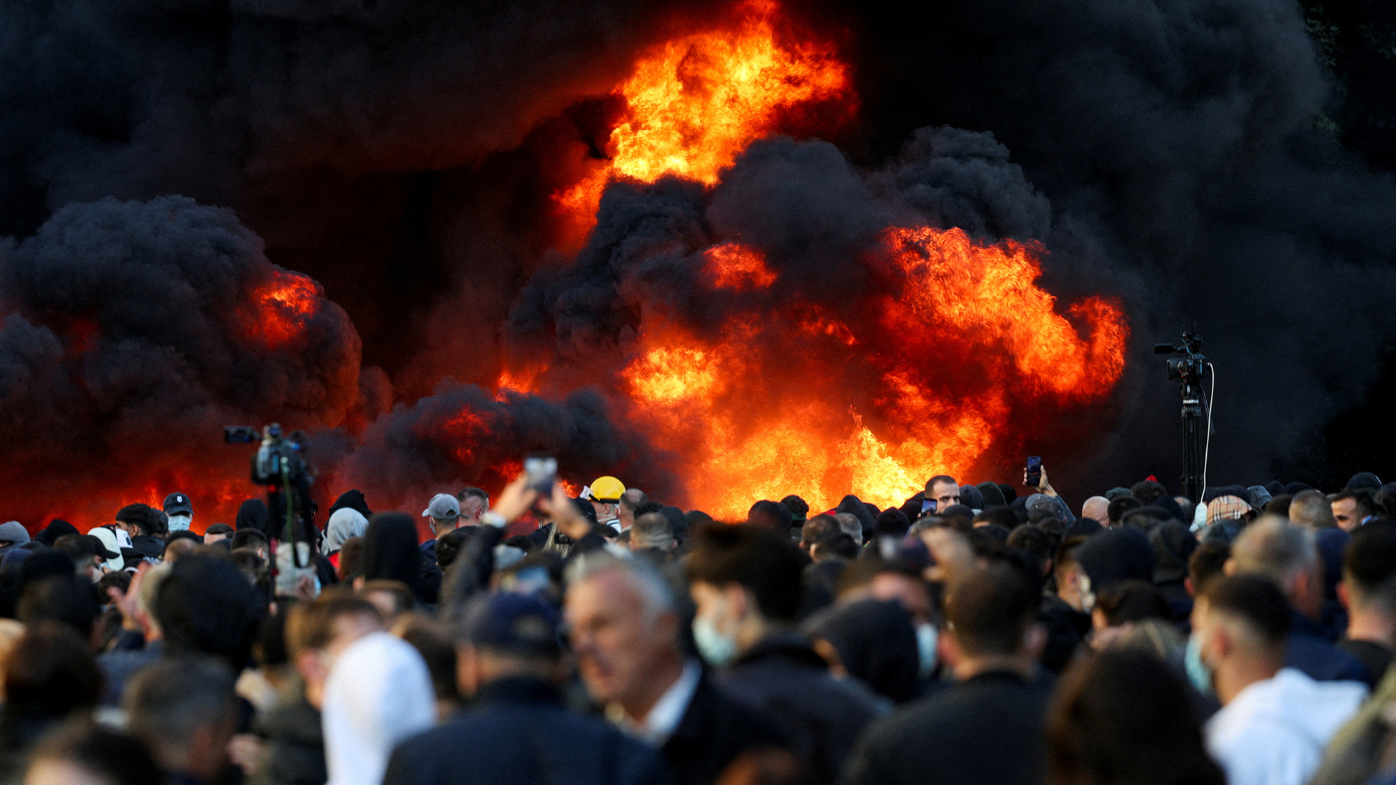 Plumes of black smoke rise during a violent anti-government protest by students in Tirana, Albania