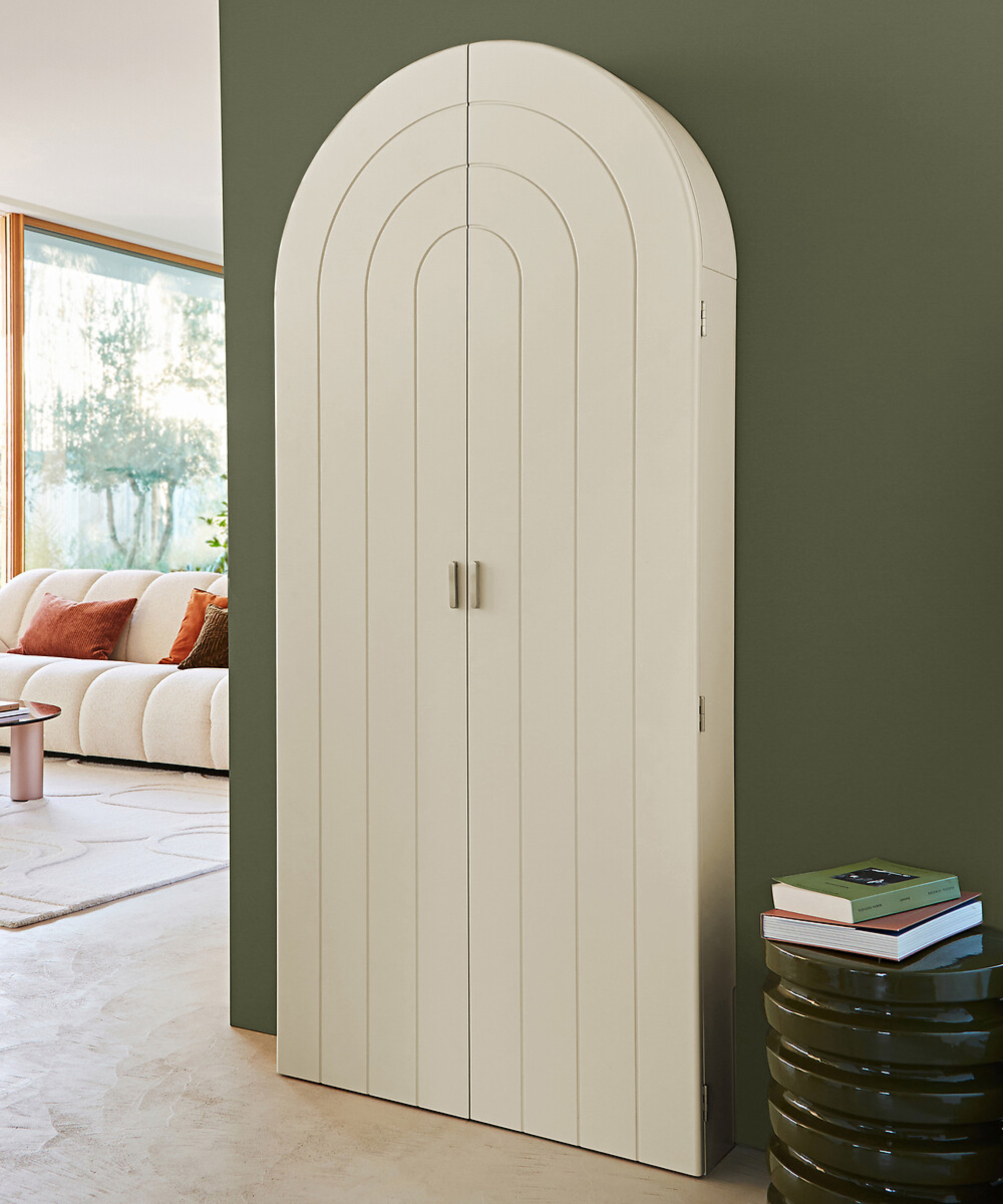 hideway desk with cream arched design closed and fitted to green wall