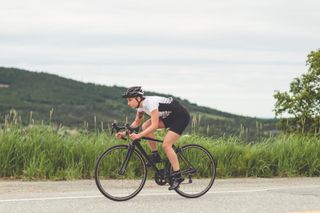 Cyclist rolls along in the drops on a road bike