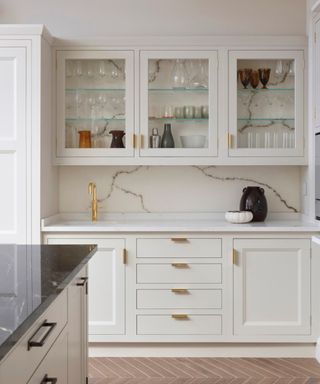 A white kitchen with glass front top cabinets