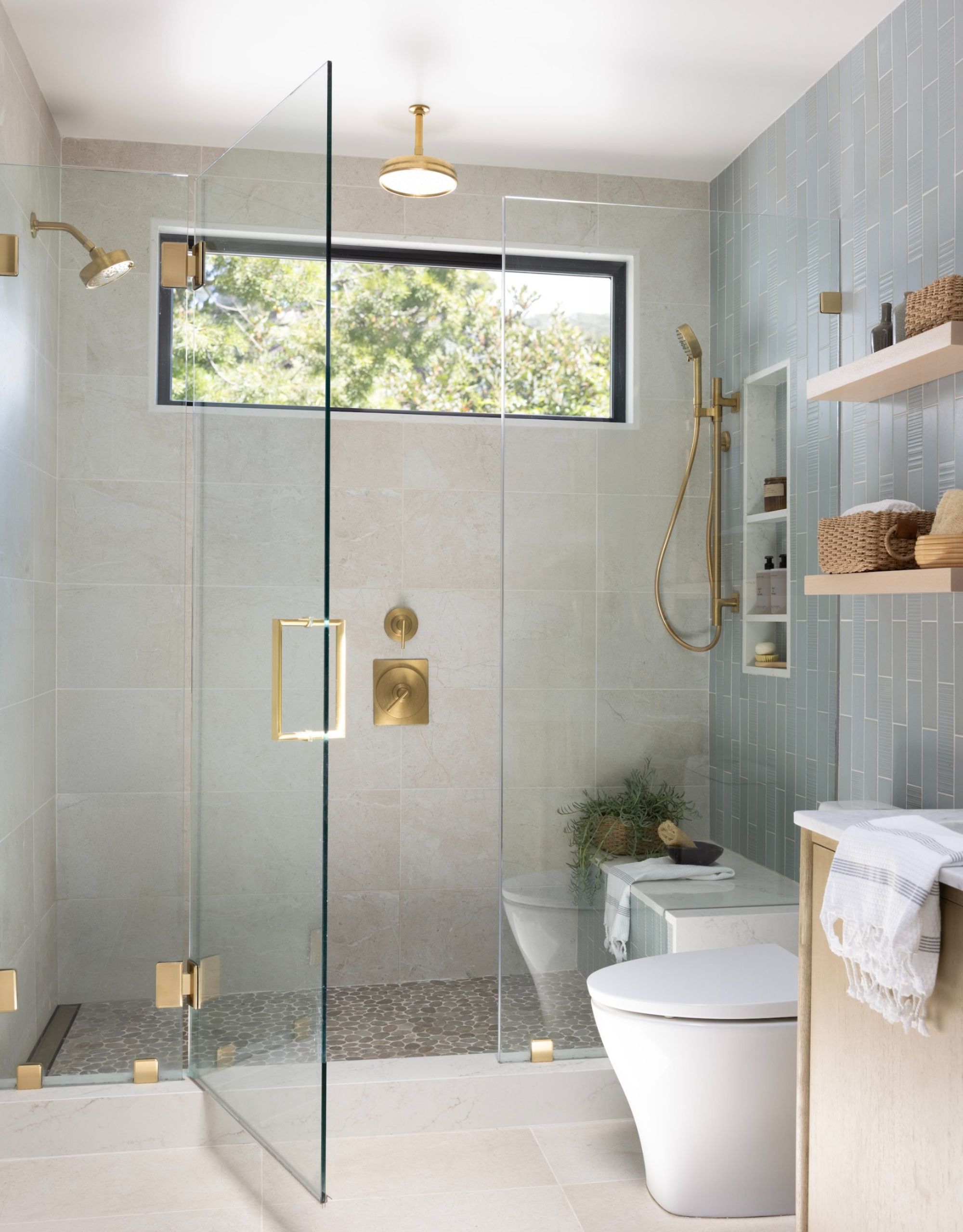 a neutral shower space with gold fixtures and fittings and a built-in shower niche