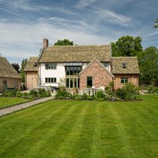 Grass lawn with stripes in front of house and patio seating area