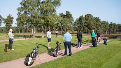 Golfers wait to play their shots