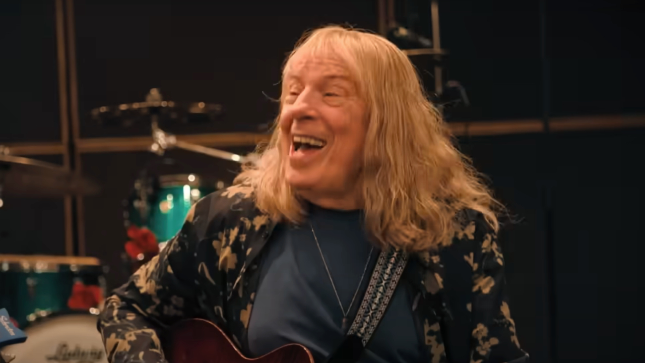 Michael McKean strumming and smiling in Spinal Tap II: The End Continues