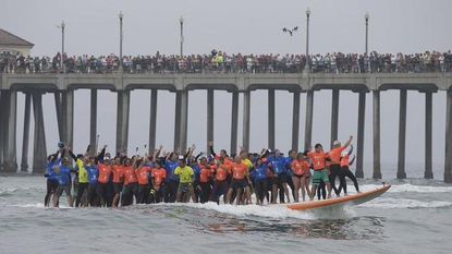 A record number of people ride a surfboard together.