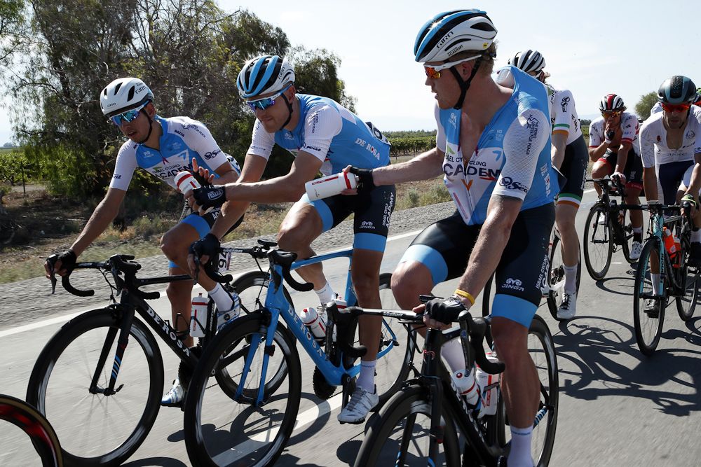 Israel Cycling Academy rider play a game of pass the bottle during stage 1 in San Juan