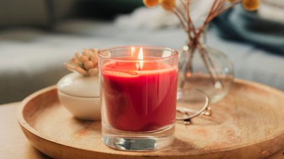 Are scented candles toxic? An example of a scented candle, a red candle on a wooden coffee table