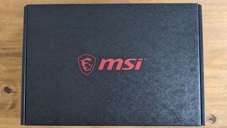 A black MSI GF63 Thin laptop on a wooden desk