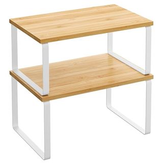 A set of two shelf risers with white metal legs and wooden tops, standing on top of one another