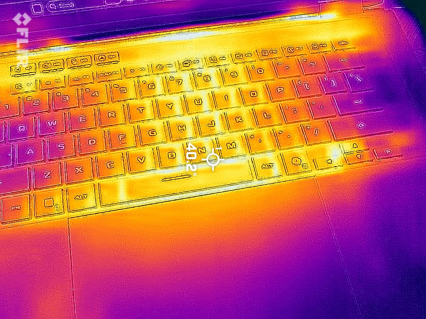 Thermal image of a laptop keyboard shows warm areas in yellow and orange, indicating heat, while cooler zones appear in purple and dark blue.