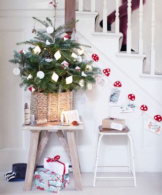 white wall with stairs and decorative mini christmas tree on wooden stool