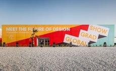 The front of The Global Grad Show. Rectangle building painted red and yellow with writing on it.