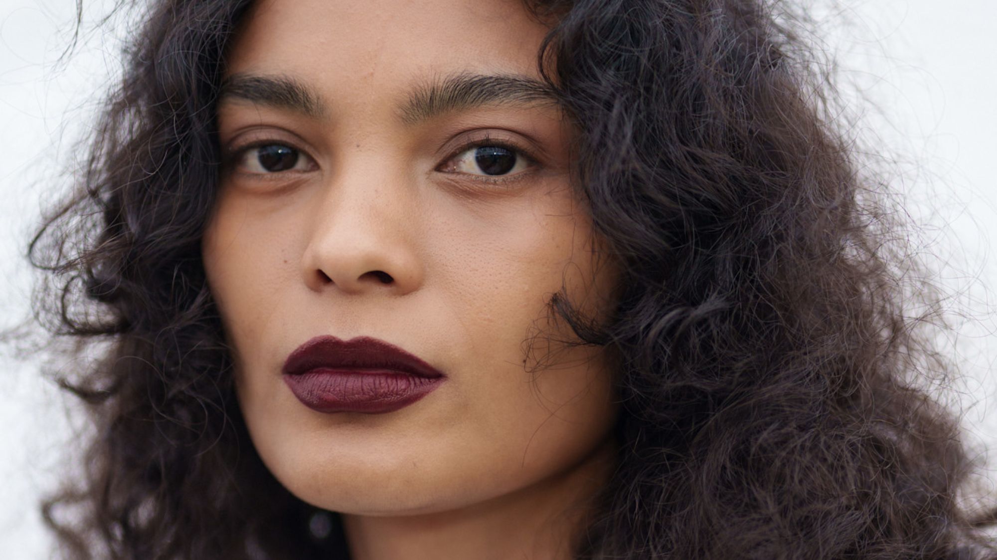 a closeup of a model's face and curly hair backstage at doublet fashion show - best silk bonnets for sleeping in