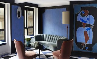 Hotel room with blue and pink chairs and blue painted walls