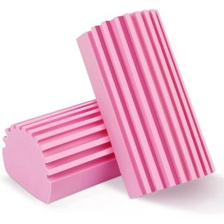 Two pink ridged damp dusters leaning against one another 