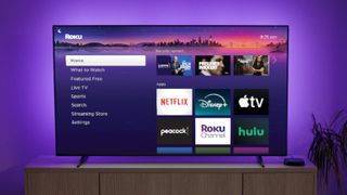 A contemporary TV displaying the Roku home screen, which showcases various streaming app icons like Netflix, Disney Plus, etc.