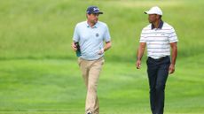 Keegan Bradley and Tiger Woods talking while walking at the 2024 PGA Championship