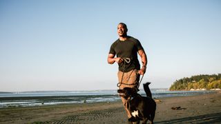 Man walking on beach with dog