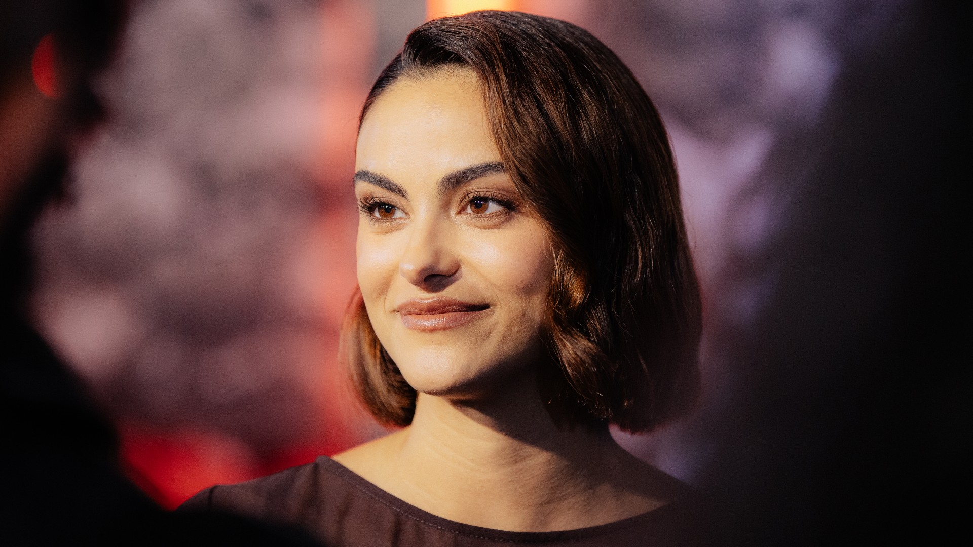 a close up red carpet photo of a latina woman with short brown hair
