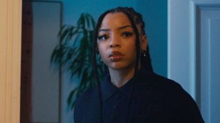 Chloe Bailey looking through door in Strung.