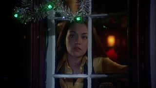 A woman looks out a window in Black Christmas
