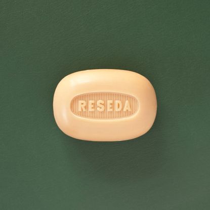A cream coloured bar of soap with the word "Reseda" imprinted on it