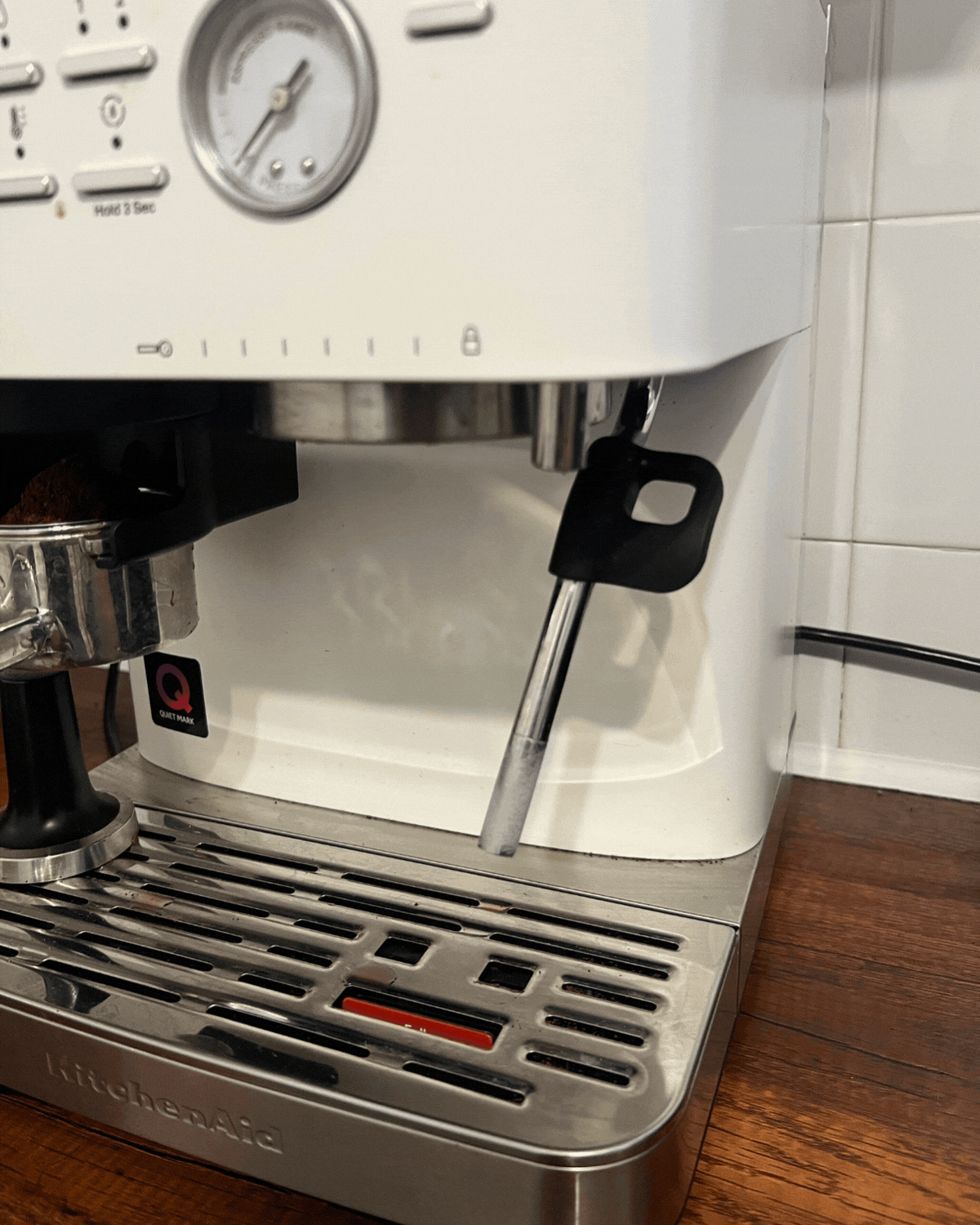 GIF of images of a white espresso machine will air coming out of the steam wand.