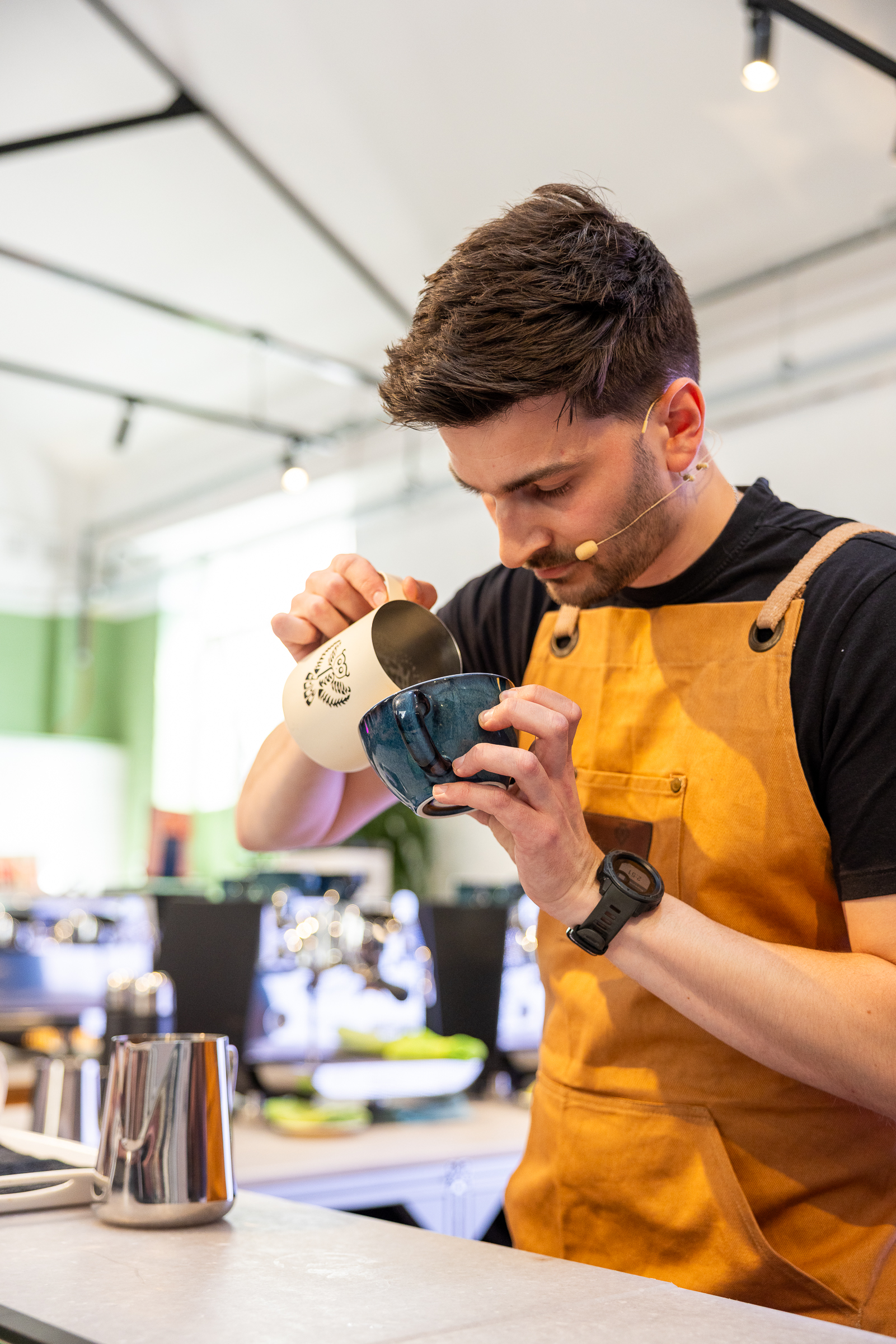 Image of barista Ben Lewis pouring milk into coffee as latte art