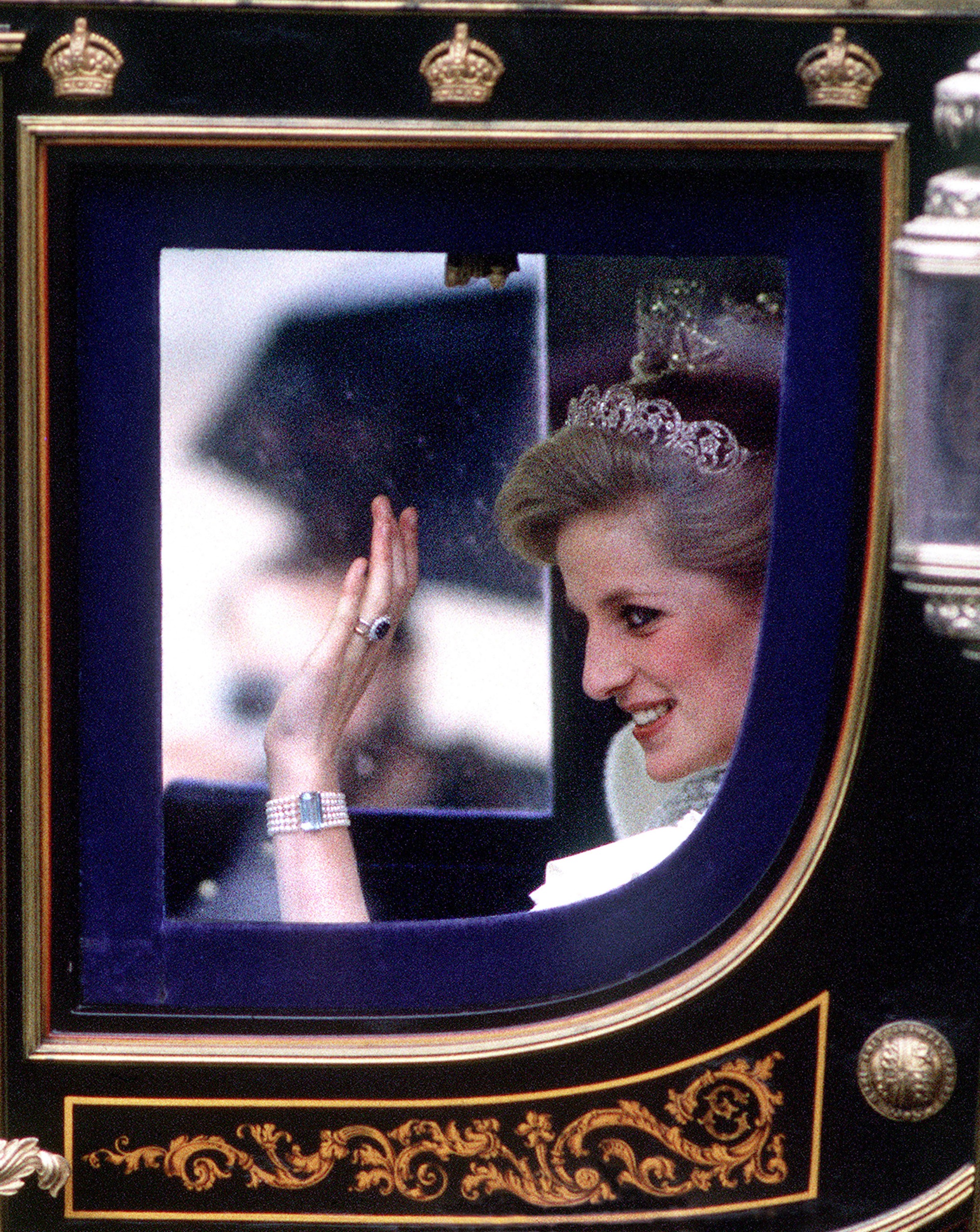 Princess Diana waving from a glass carriage wearing a tiara