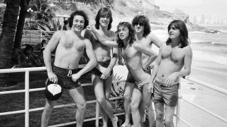 A shirtless AC/DC pose on a terrace in Rio