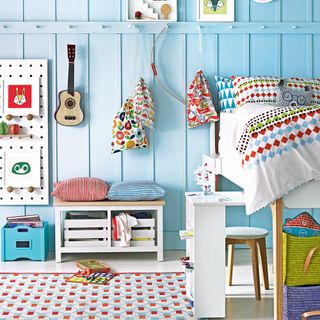 kids bedroom with blue panelled wall and peg storage