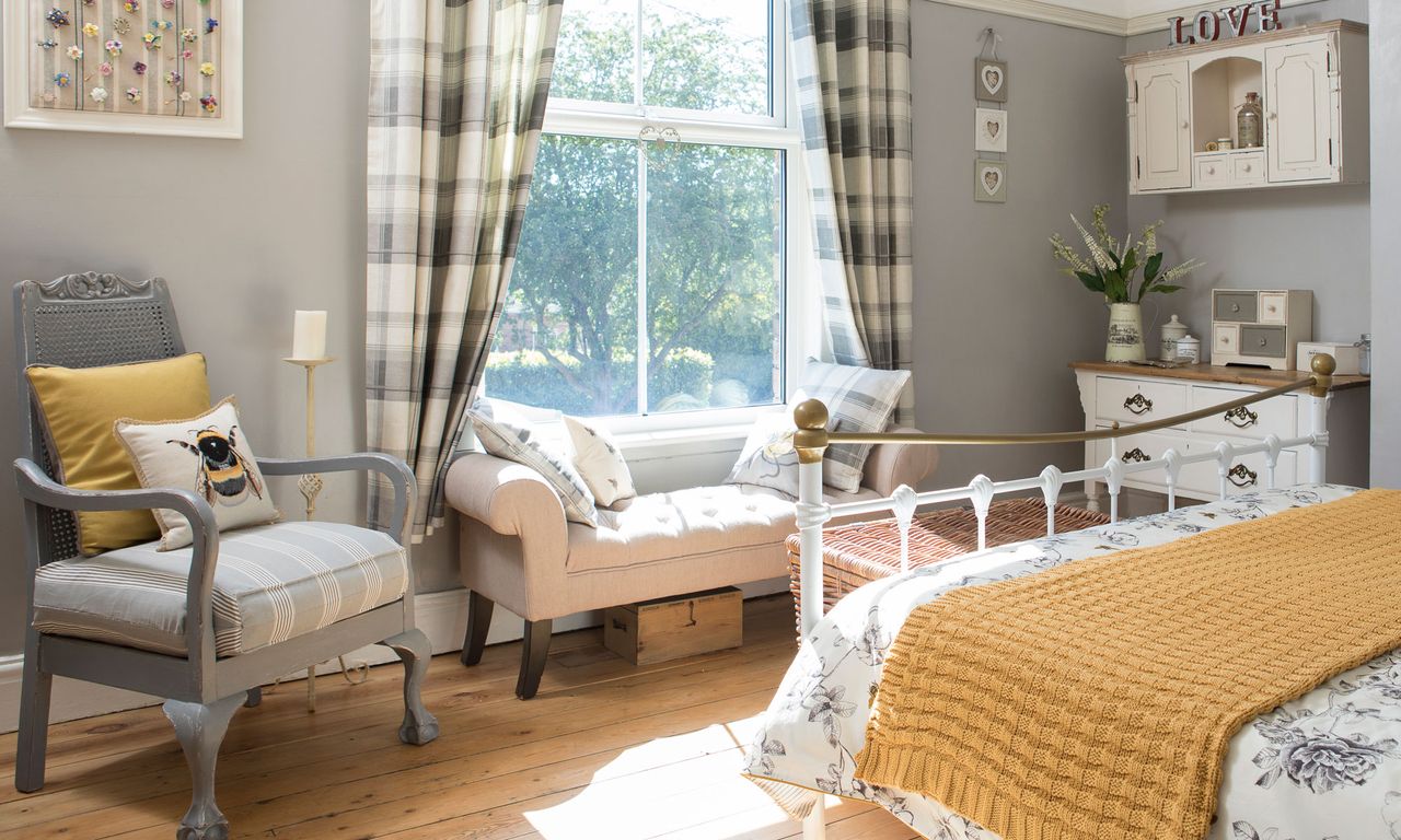 bedroom with grey walls checkered curtains and wooden flooring