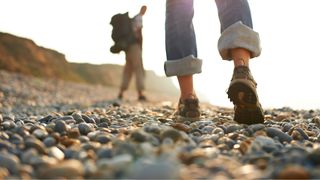 Woman's shoes walking along pebble beach