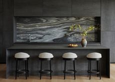 a dark gray minimalist kitchen with a marble backsplash