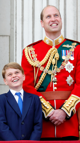 Prince George of Cambridge and Prince William, Duke of Cambridge (wearing the uniform of Colonel of the Irish Guards) watch a flypast from the balcony of Buckingham Palace during Trooping the Colour on June 2, 2022 in London, England